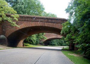 photo shows a large brick bridge over a concrete walkway
